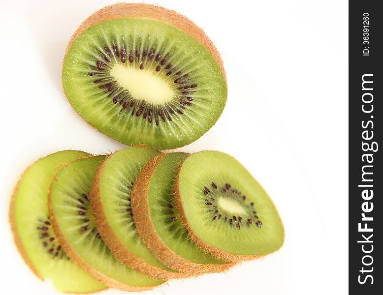 Whole kiwi fruit and it's sliced segments isolated on white background