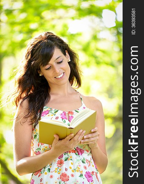 Woman reading and walking on park