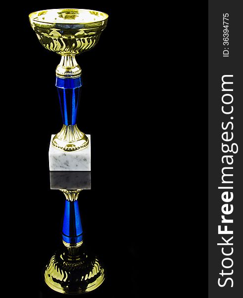 Gold trophy, black background, vertical