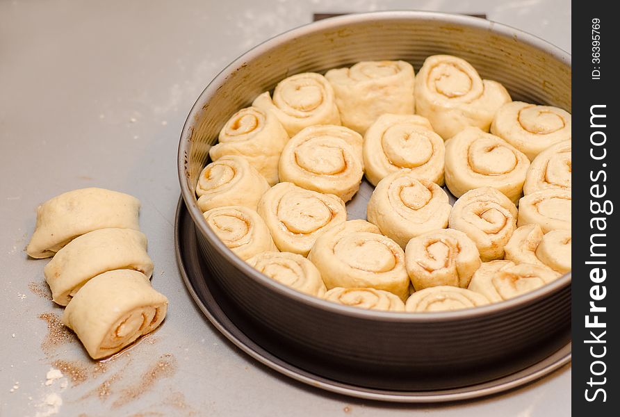 Preparing cinnamon rolls on kitchen table