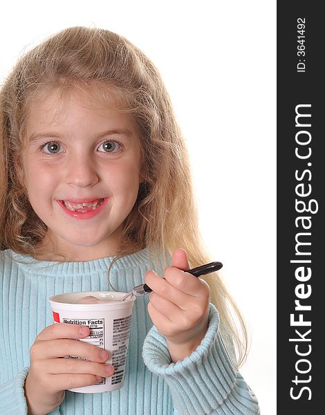 Happy little girl eating yogurt vertical