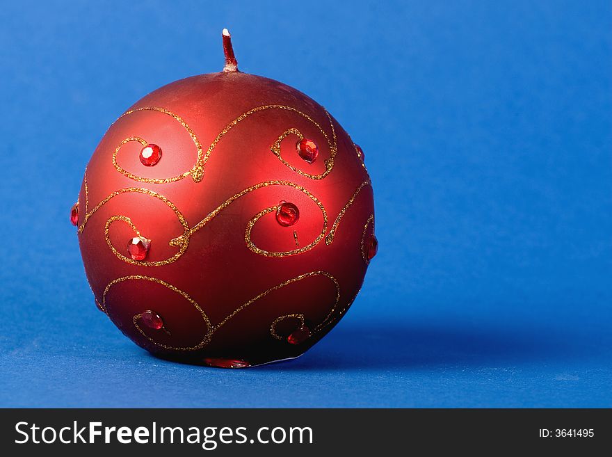 Round christmas candle with golden decorations