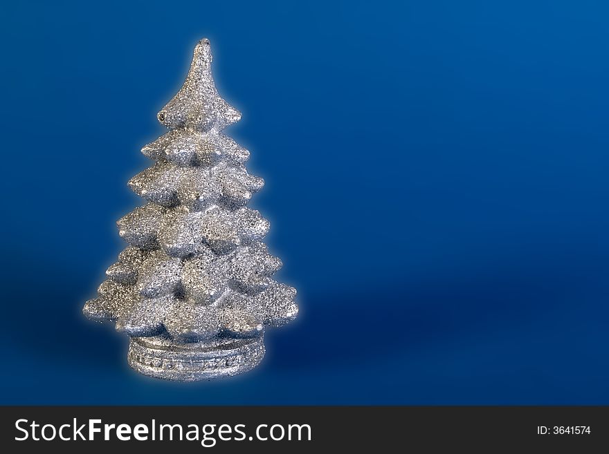 Glowing silver christmas tree on blue background. Glowing silver christmas tree on blue background