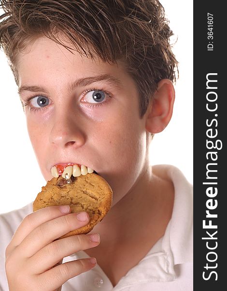 Young boy with rotten teeth eating a cookie