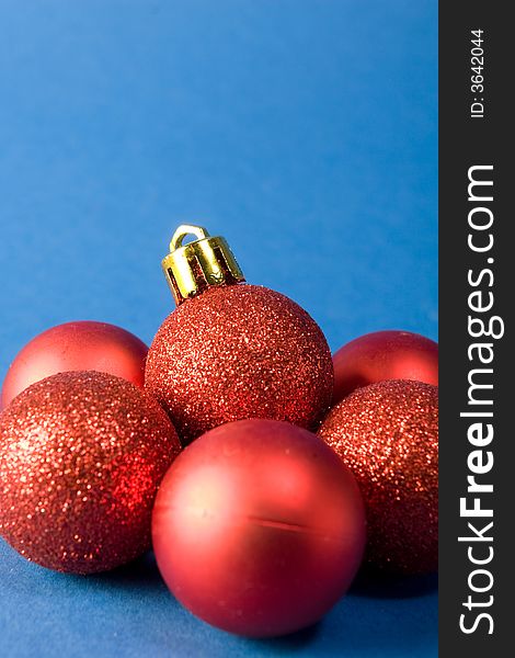 Group of small red christmas globes on blue background. Group of small red christmas globes on blue background