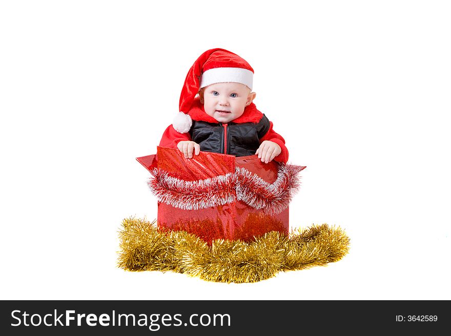 Happy infant with red cap in a decorated christmas box. Happy infant with red cap in a decorated christmas box