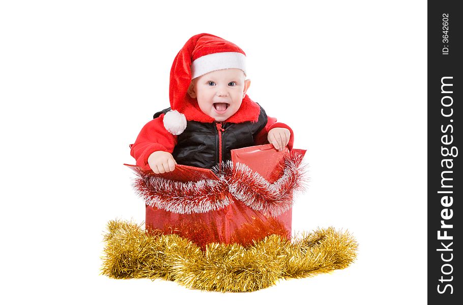 Happy infant with red cap in a decorated christmas box. Happy infant with red cap in a decorated christmas box