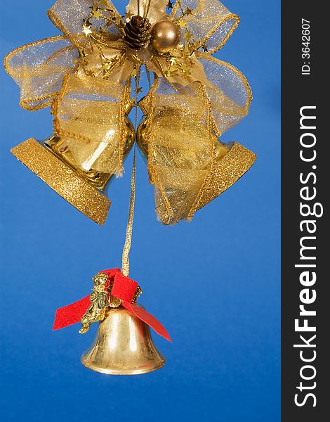 Golden bells and decorative ribbon on blue background. Golden bells and decorative ribbon on blue background