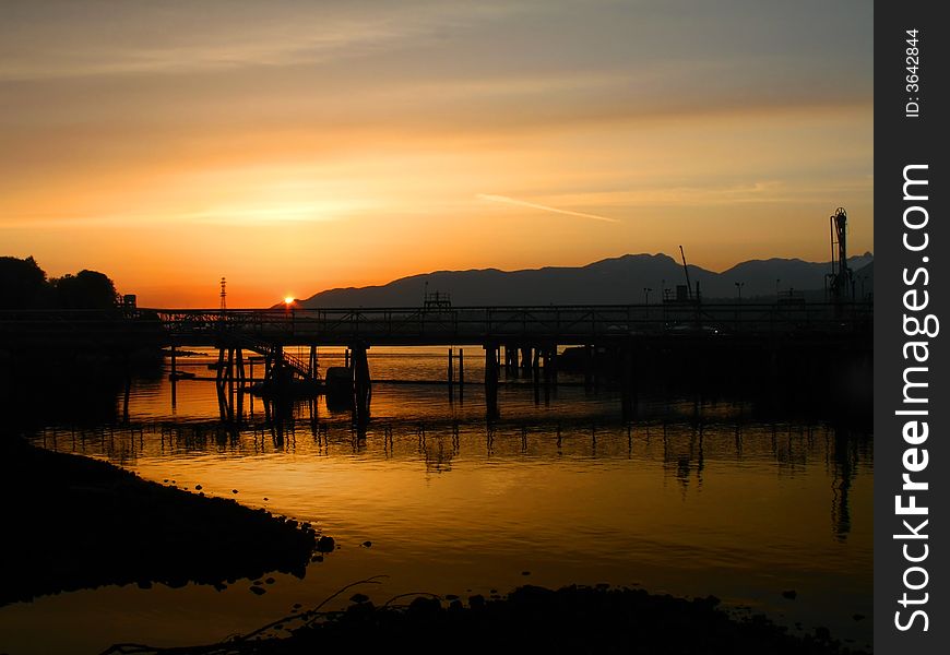 Intense orange sunset over a rock beach in Vancouver.