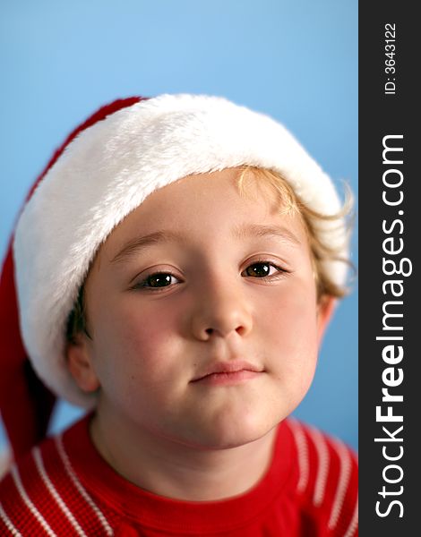 Young boy wearing a santa hat on a blue background