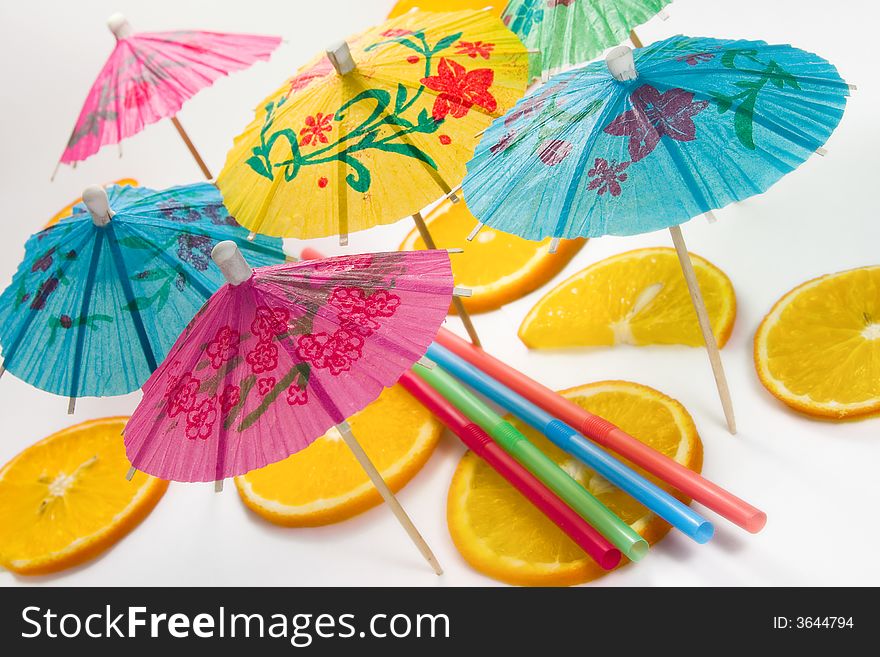 Straw, slices of  orange and decorative umbrellas. Straw, slices of  orange and decorative umbrellas