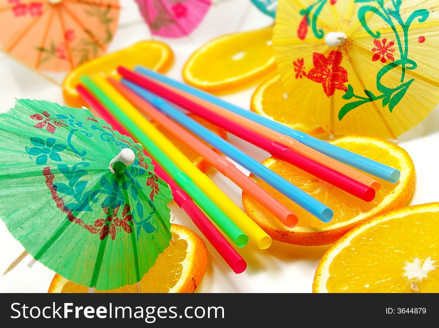Straw, slices of orange and decorative umbrellas. Straw, slices of orange and decorative umbrellas