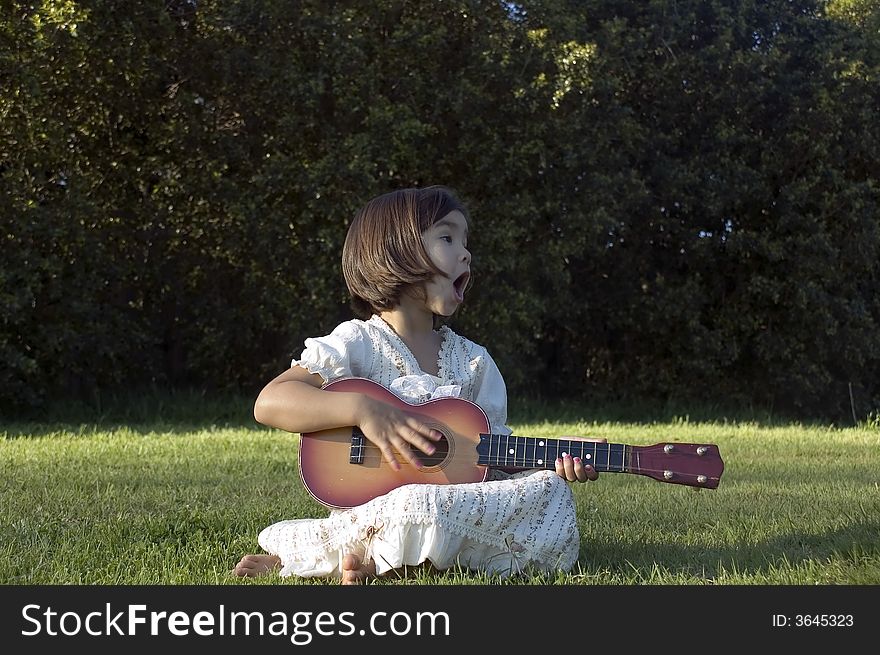 Girl with guitar on the lawn. Girl with guitar on the lawn