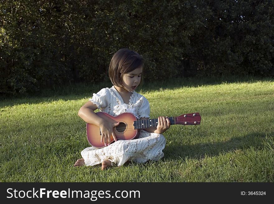Girl with guitar on the lawn