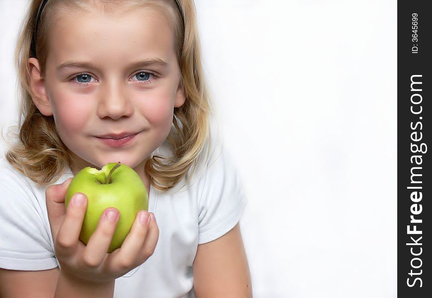 An adorable boy is holding a green apple. An adorable boy is holding a green apple.