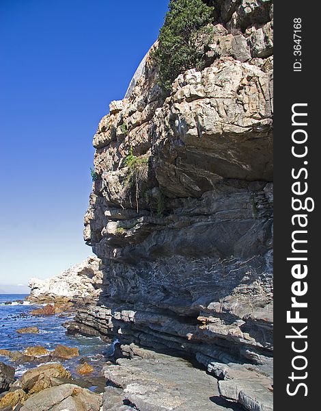 Rocky coastline of Hermanus South Africa with blue skies. Rocky coastline of Hermanus South Africa with blue skies