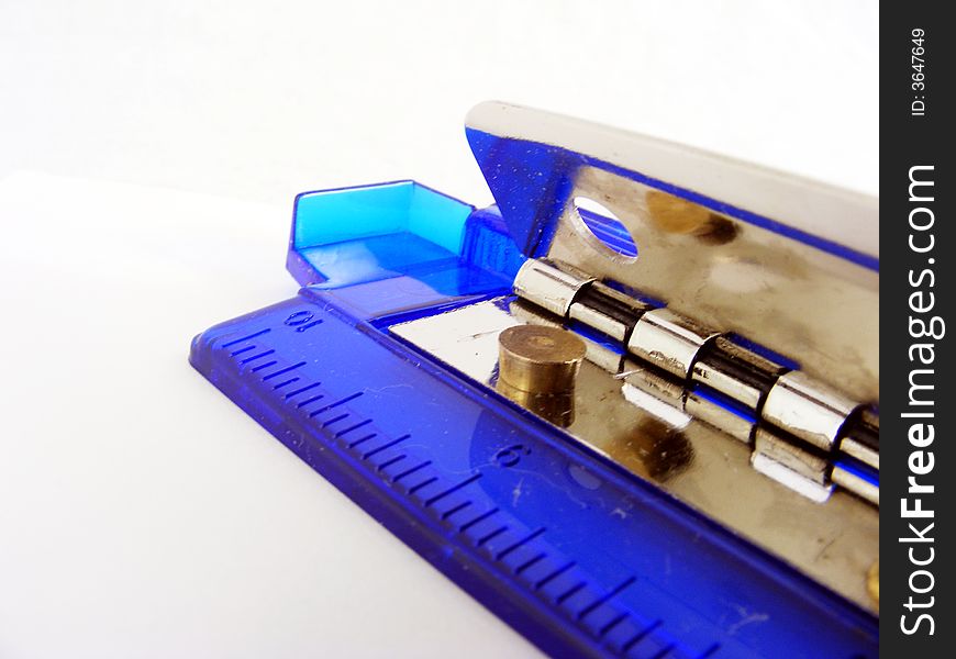 A blue plastic hole puncher for paper against a white background. A blue plastic hole puncher for paper against a white background.