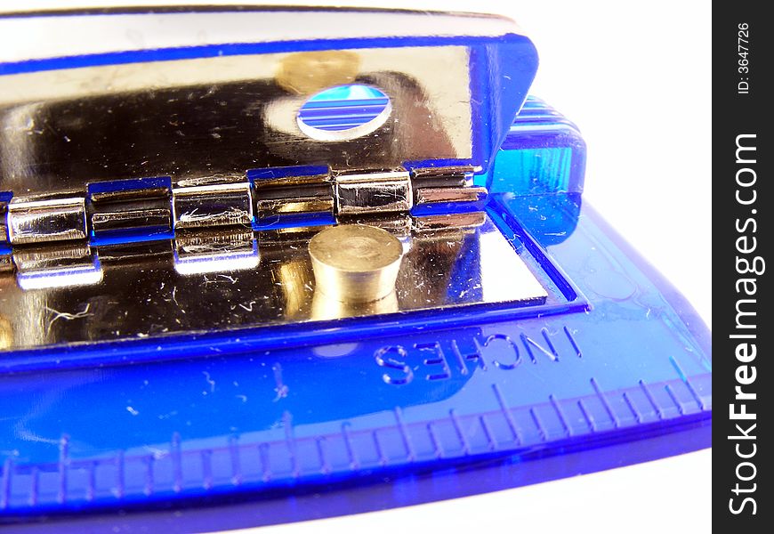 A blue plastic hole puncher for paper against a white background. A blue plastic hole puncher for paper against a white background.
