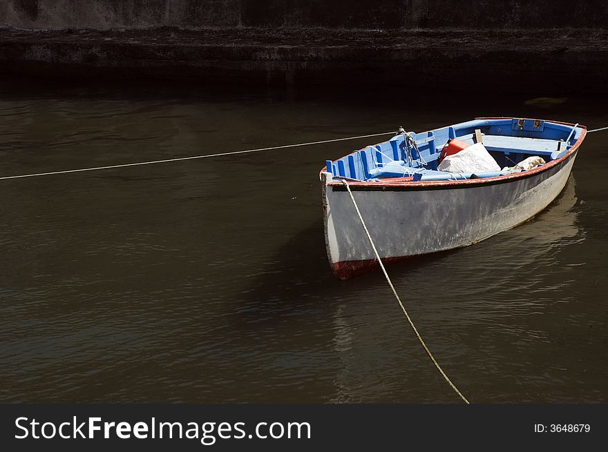 Small fishing rowboat moored at harbour