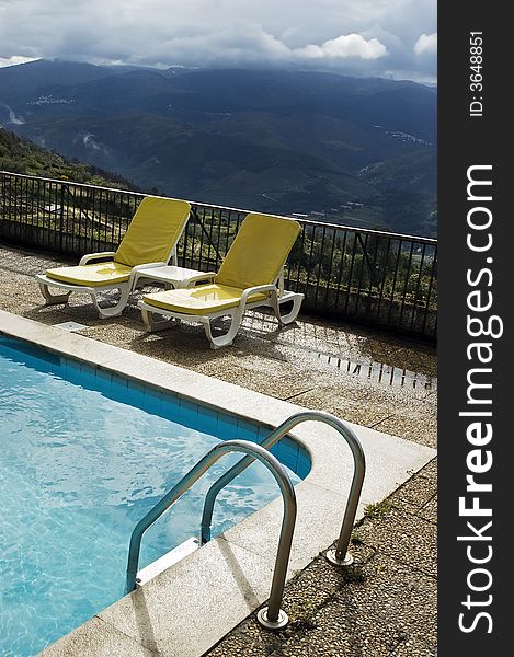 Long chairs by the pool in a mountain landscape. Long chairs by the pool in a mountain landscape