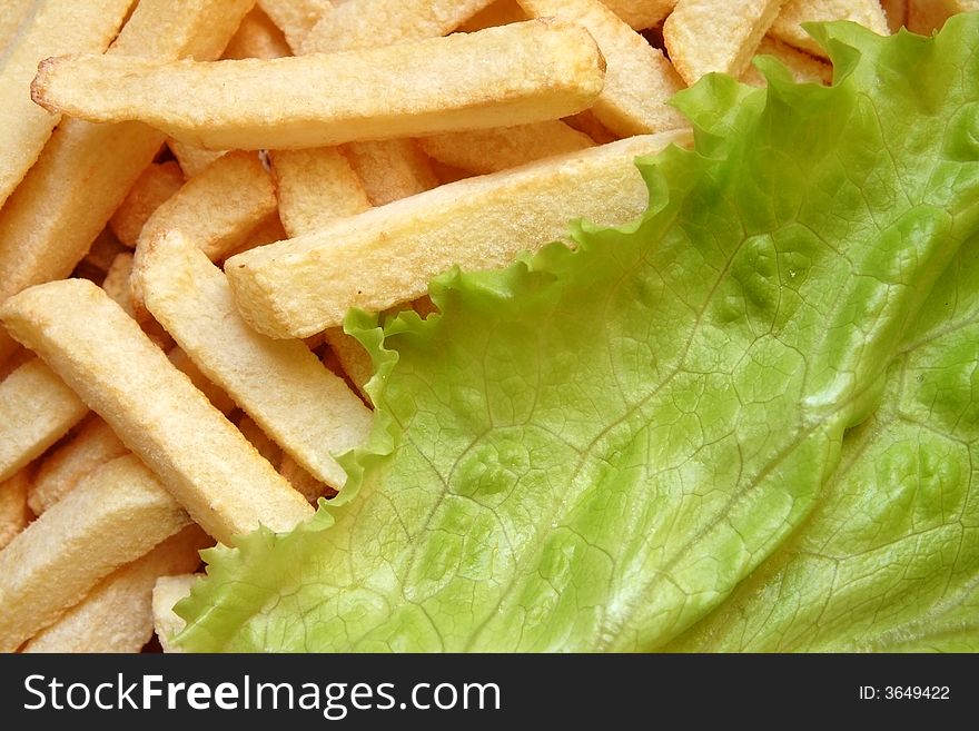 Close up of french fries and lettuce salad