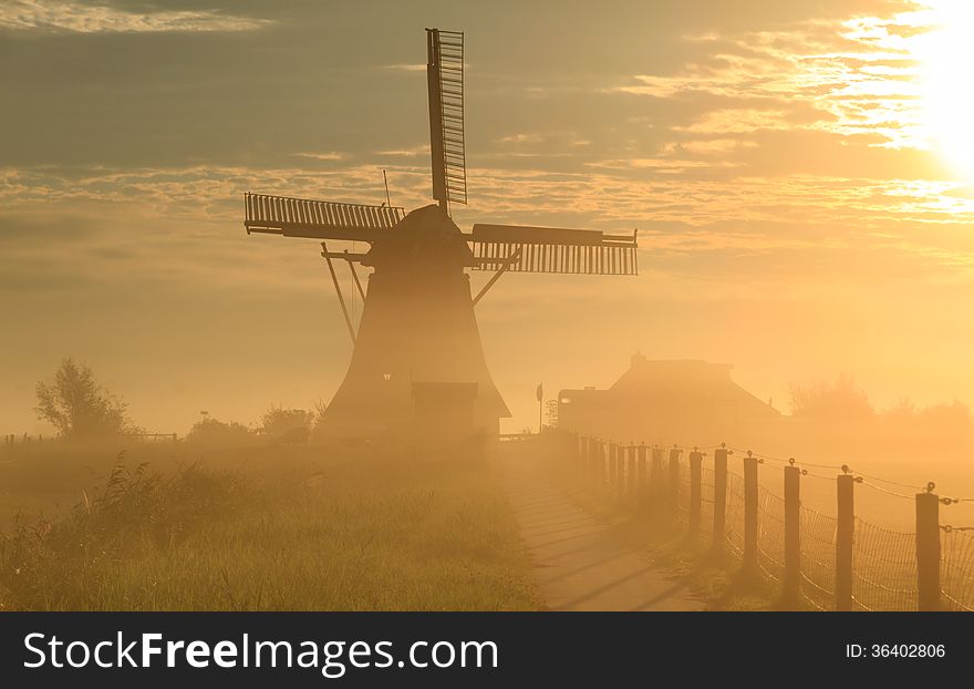Foggy, autumn sunrise in the Dutch countryside near a windmill. Foggy, autumn sunrise in the Dutch countryside near a windmill.