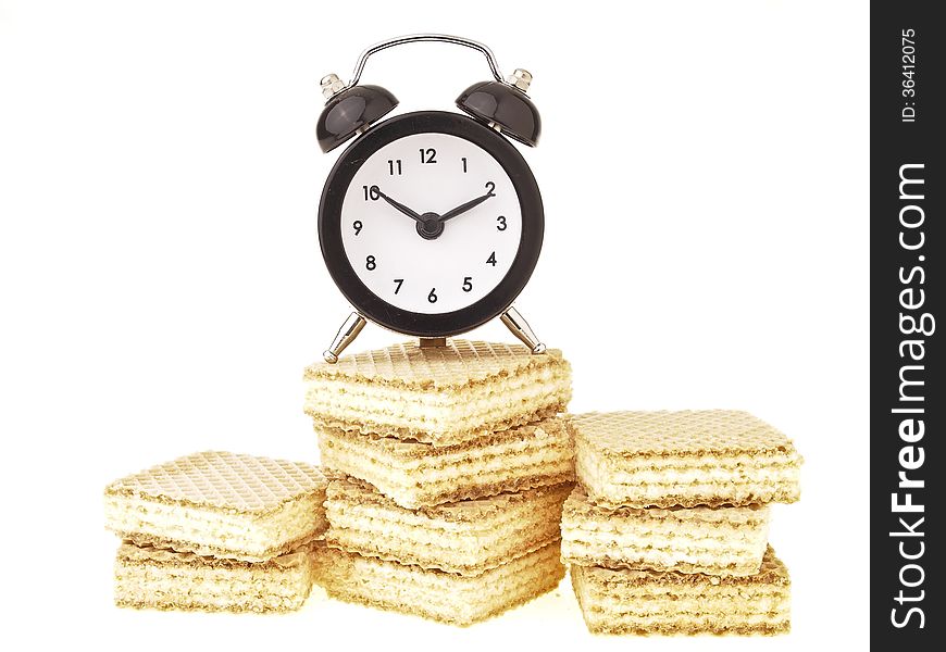 Alarm clock on wafer pile isolated on white background. Alarm clock on wafer pile isolated on white background