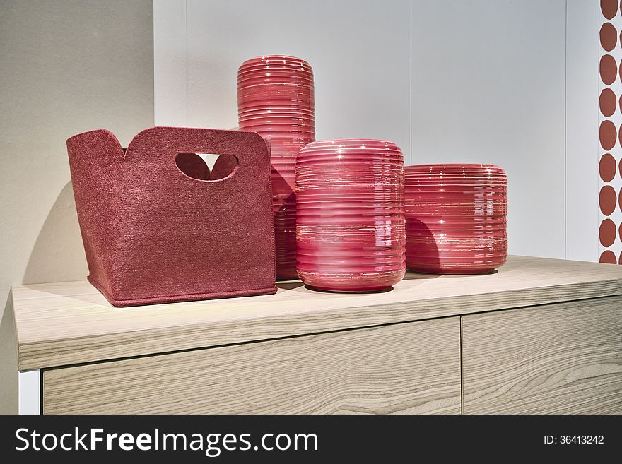 Red bag and red ceramic vases on the chest of drawerrs. Red bag and red ceramic vases on the chest of drawerrs