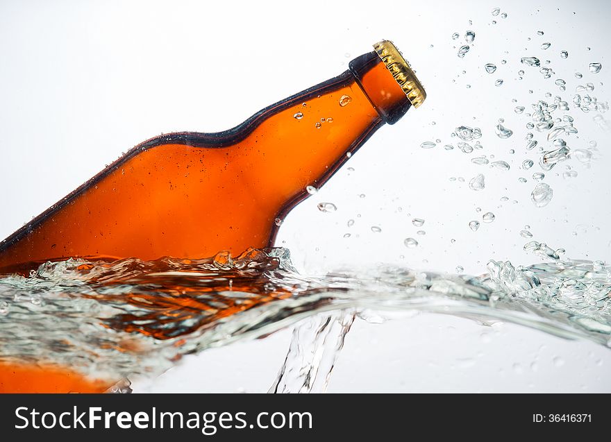 Image of beer bottle in water on a white background