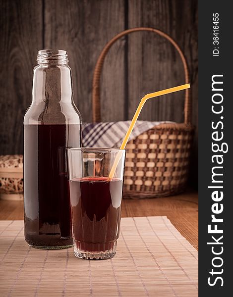 Bottle And Glass Of Red Juice On A Wooden Table