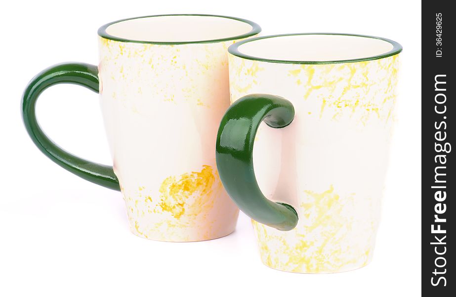 Pair of Beige Tea Cups with Green Handles isolated on white background. Pair of Beige Tea Cups with Green Handles isolated on white background