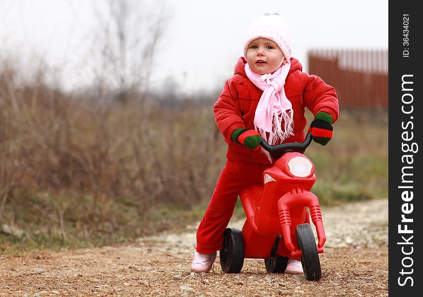 Gorgeous baby girl playing with her first bike. Gorgeous baby girl playing with her first bike