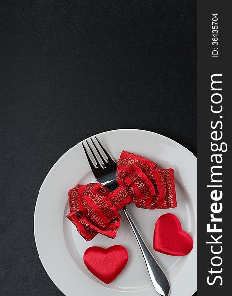 Festive table setting for Valentine's Day on a black background, vertical. Festive table setting for Valentine's Day on a black background, vertical