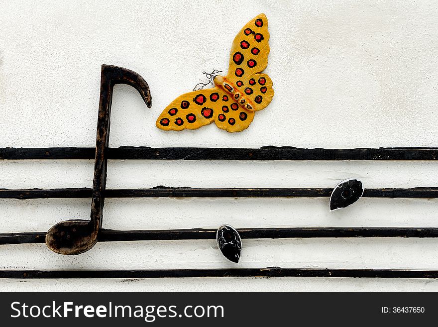 Butterfly and musical note on concrete wall