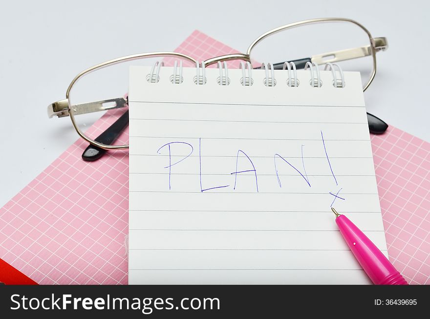 Pink pen notebook and glasses wording plan