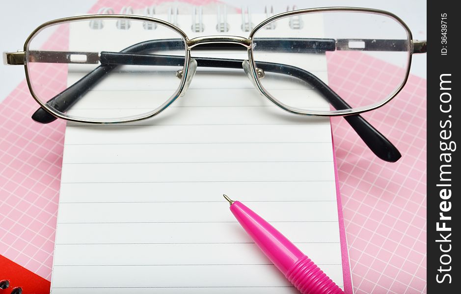 Pink pen notebook and glasses empty message