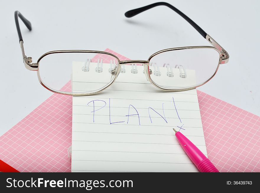 Wording Plan messege on pink pen notebook with glasses