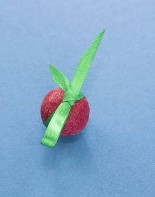 Red Praline With Green Ribbon On Blue Background Stock Photos Red Praline With Green Ribbon On Blue Background Stock Photos