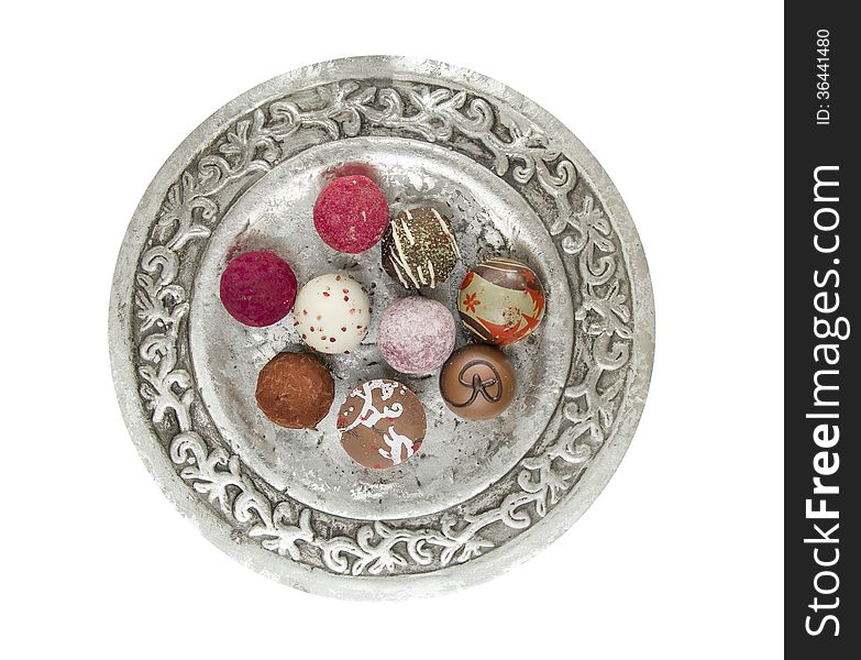 Round silver tray with colorfull pralines on white background. Round silver tray with colorfull pralines on white background