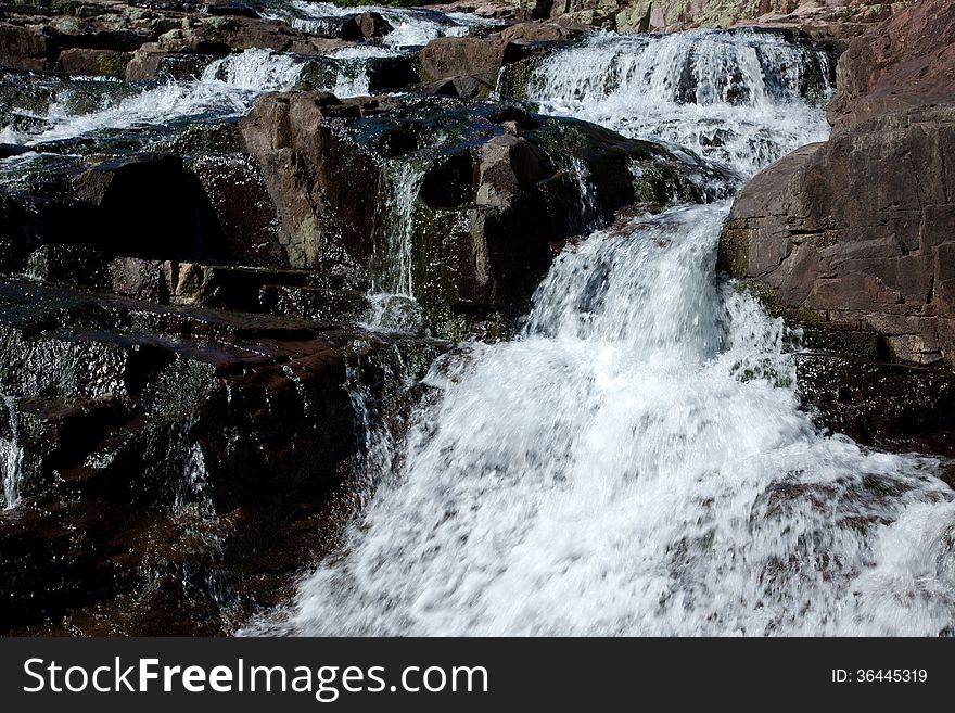 Water cascading over and around large rocks. Water cascading over and around large rocks.