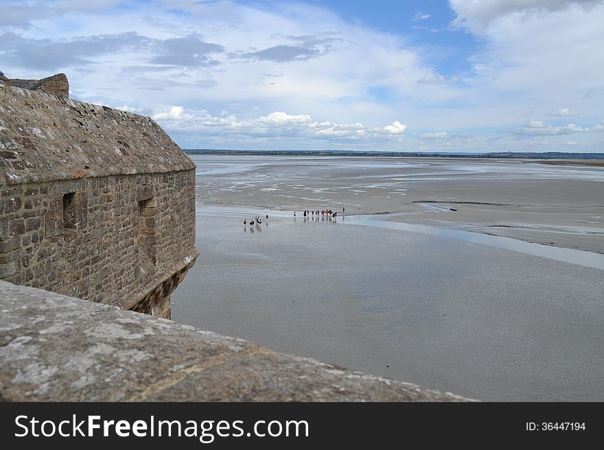 The city wall and the low tide infront of Mont Saint Michel Island west of France. The city wall and the low tide infront of Mont Saint Michel Island west of France