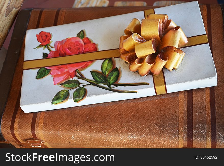 Box of chocolate seating on a suit case