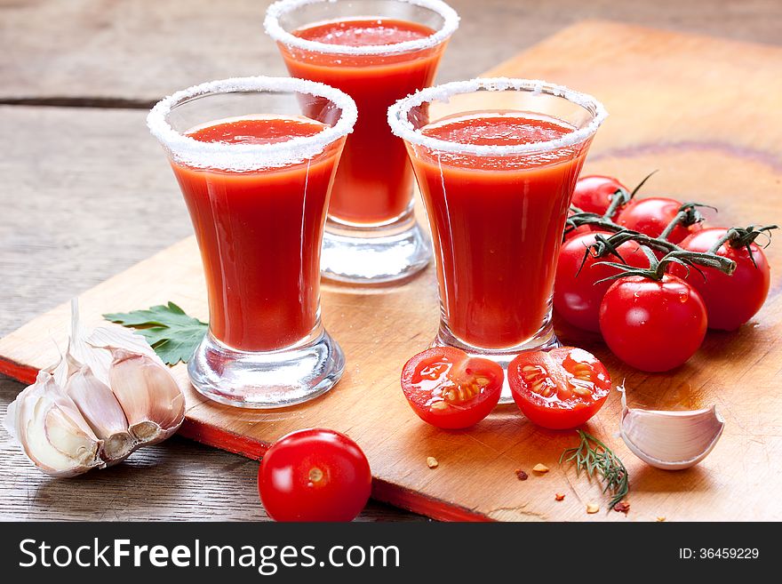 Tomato juice, tomatoes, garlic and spices on a table. Tomato juice, tomatoes, garlic and spices on a table