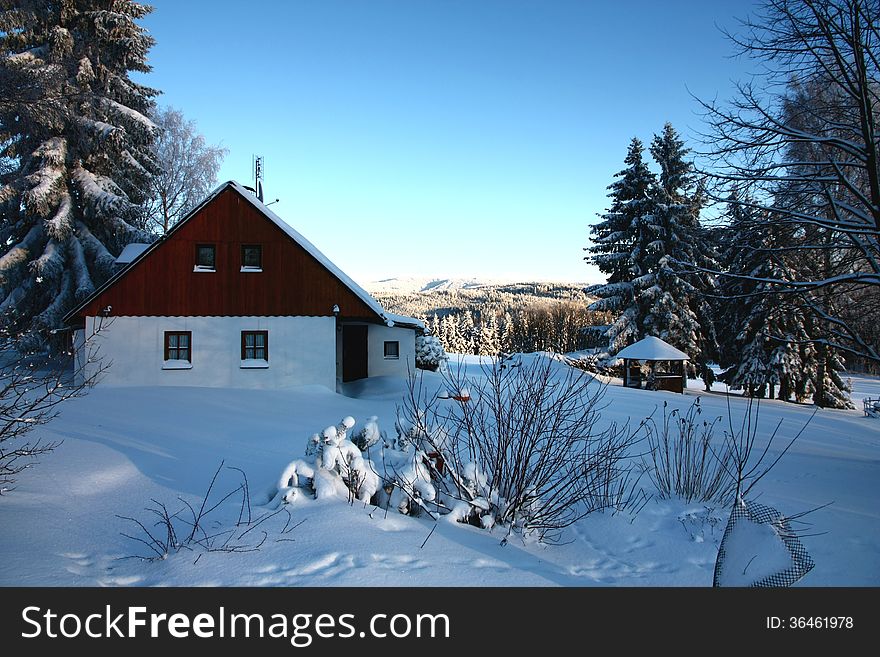 Half-timbered cottage in winter landscape, cottage in the shade