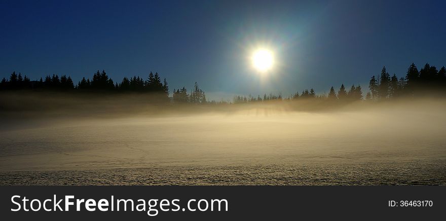 A fog is rising from the snow on a later winter afternoon in the foothills of the Bavarian Alps near the Pilgrimage Church of Wies. A fog is rising from the snow on a later winter afternoon in the foothills of the Bavarian Alps near the Pilgrimage Church of Wies.