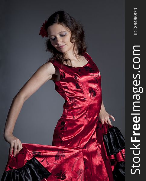 Young woman dancing flamenco, studio shot, gray background