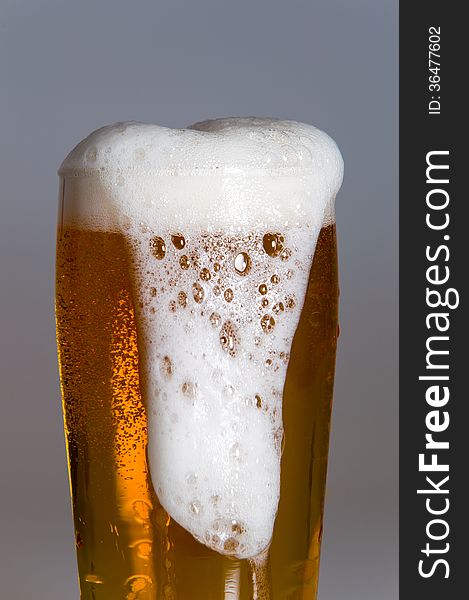 Glass of beer with foam isolated on white background