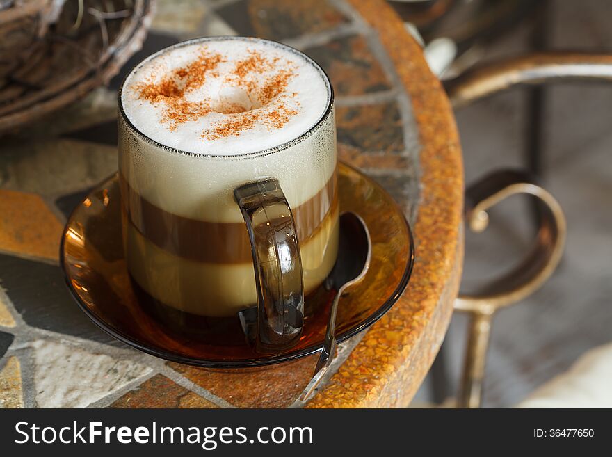 Transparent cup of cappuccino with cinnamon