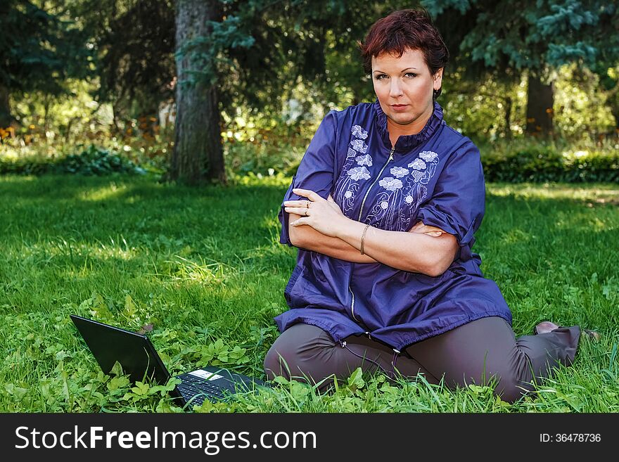 Woman With Laptop On Green Lawn.