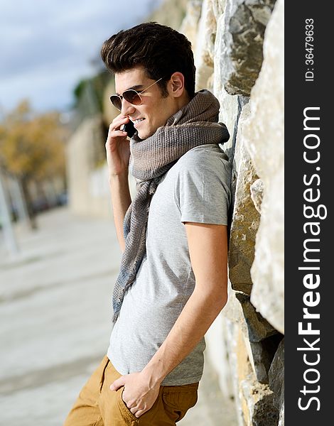 Portrait of handsome man in urban background talking on phone